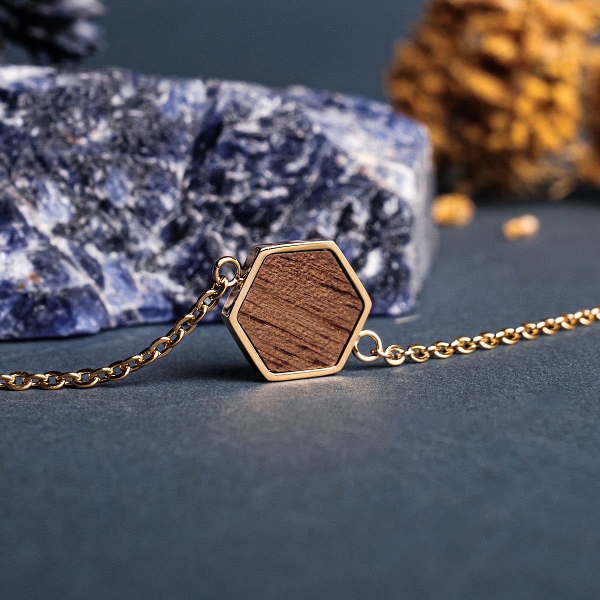"Facade Bracciale" presenta un design geometrico sorprendente con legno di noce in oro, creando un sofisticato stile bracciale.