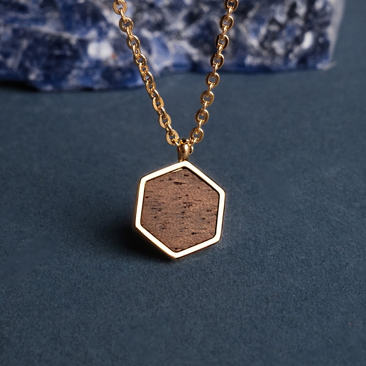 "Facade Necklace" necklace featuring a walnut and gold hexagon pendant, offering a natural and elegant style.