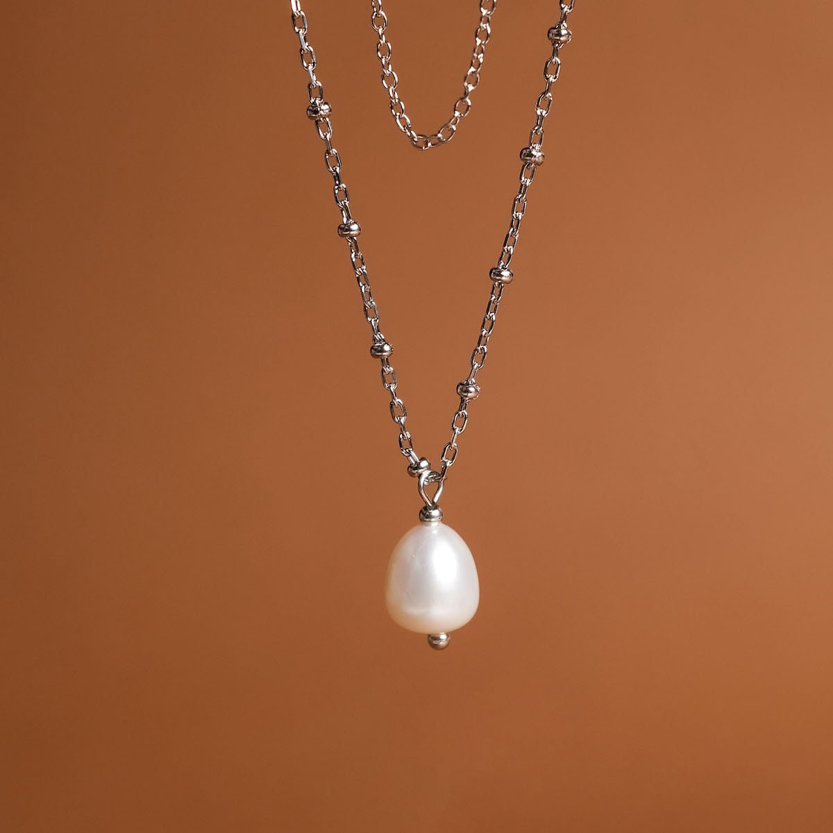 "Panoramic Necklace", a silver necklace with a white pearl pendant, showcasing elegant minimalist design.
