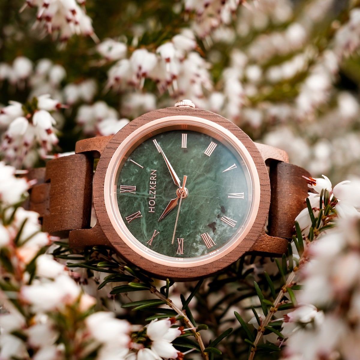 Orologio "Nymph" con corpo di noce e quadrante in marmo, circondato da fiori fiori fiori fiorenti.