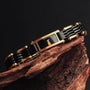 "Adagio" bracelet featuring a sleek marble and gold design, elegantly displayed on a wooden surface.