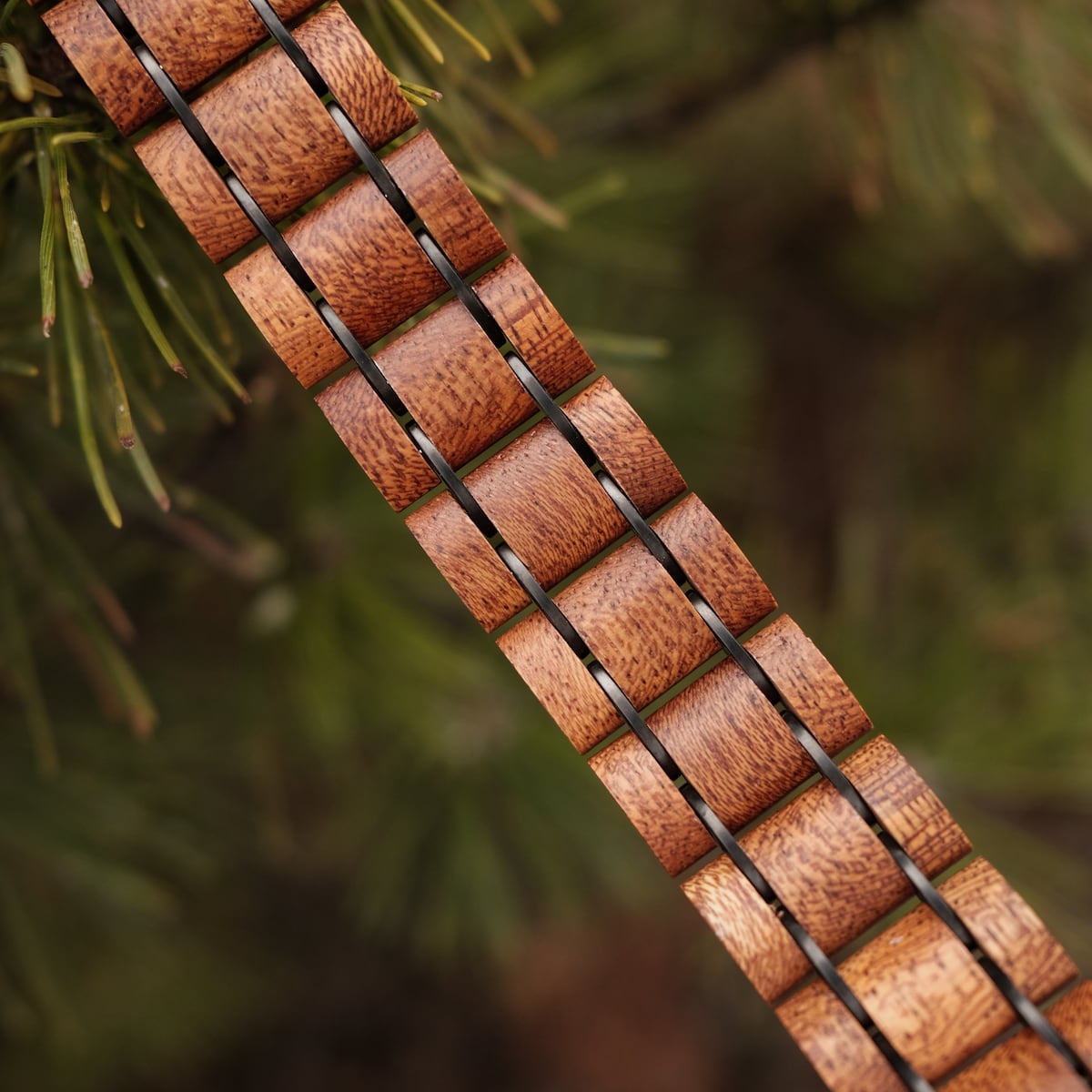 "Grandezza, wooden bracelet featuring a mahogany and gray design on a natural background."