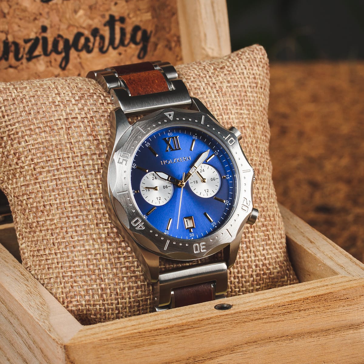 "Osprey watch featuring a vibrant azure blue dial with a metallic strap, set in a rustic wooden box."