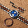 "Osprey watch featuring a striking koa and azure blue design, displayed with additional links and tools on a wooden surface."