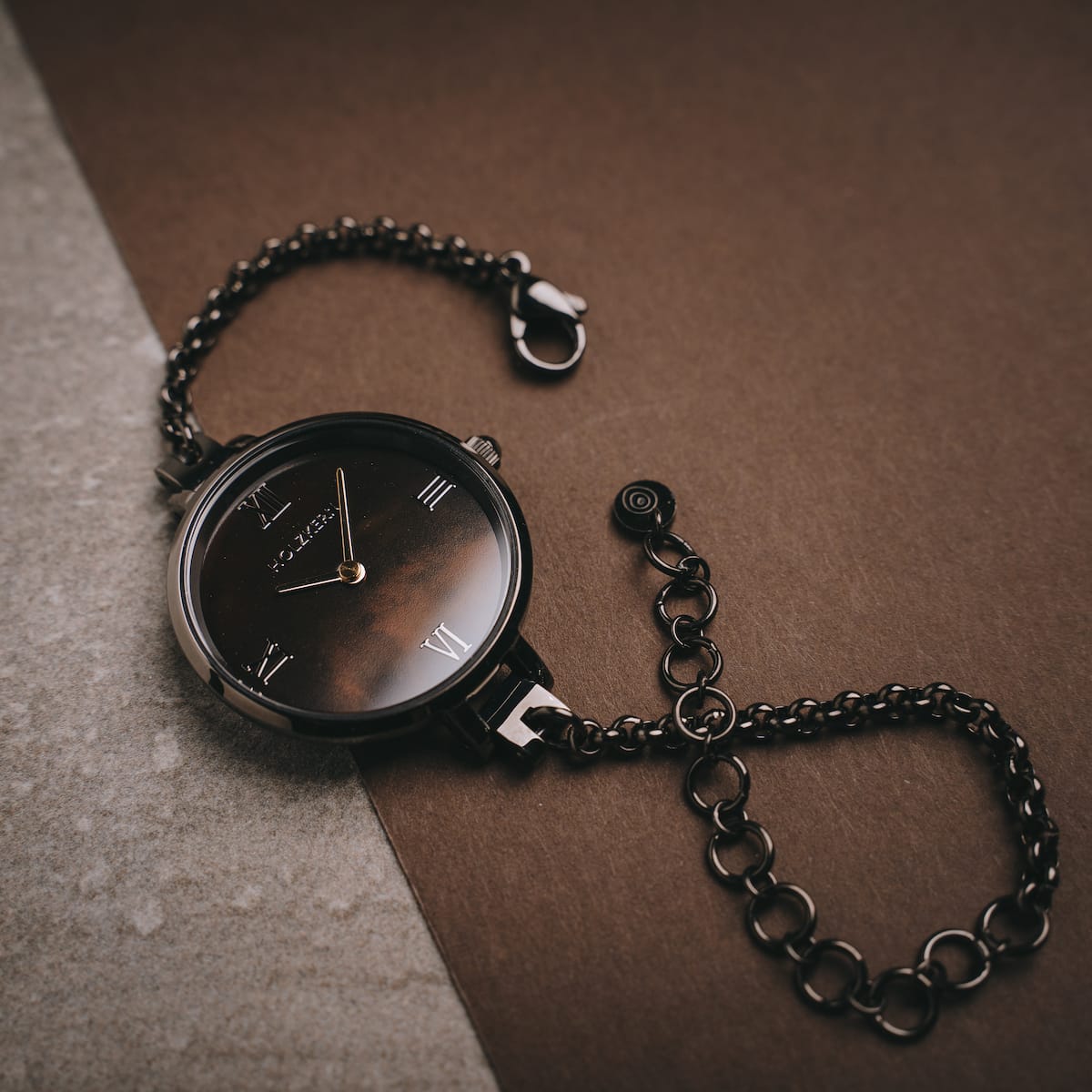 Orologio "Élisa" con un design grigio scuro e accenti nacre, con una catena di cinturino per un look elegante.
