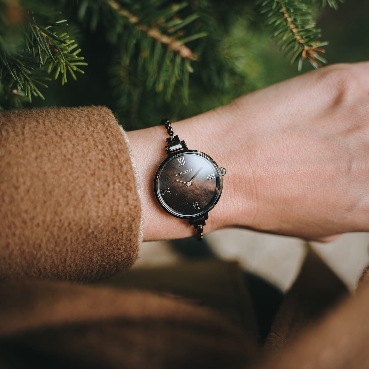 "Élisa", un elegante orologio con un viso grigio scuro e accenti nacre, che mostra uno stile senza tempo su un polso.