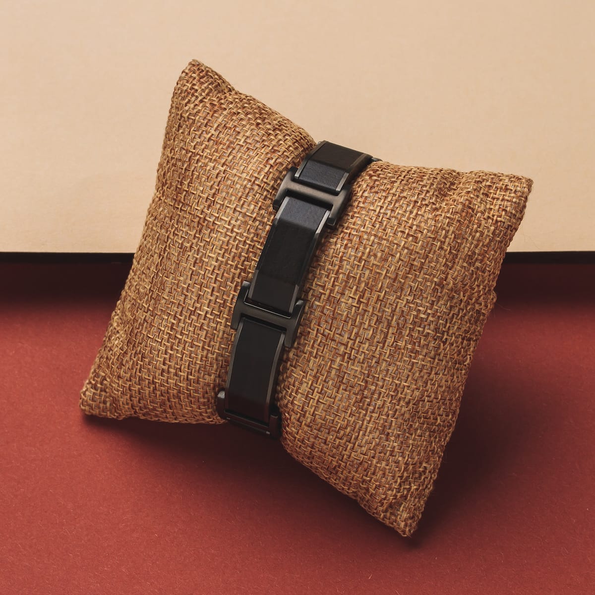"Acapella" watch with a Leadwood and dark grey design, displayed on a textured cushion.