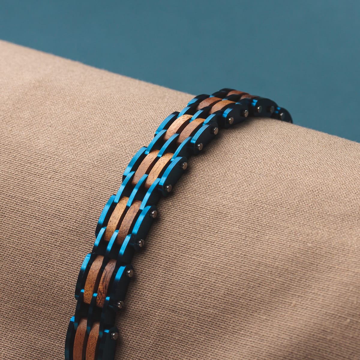 "Adagio" bracelet featuring koa wood and blue accents on a beige background.