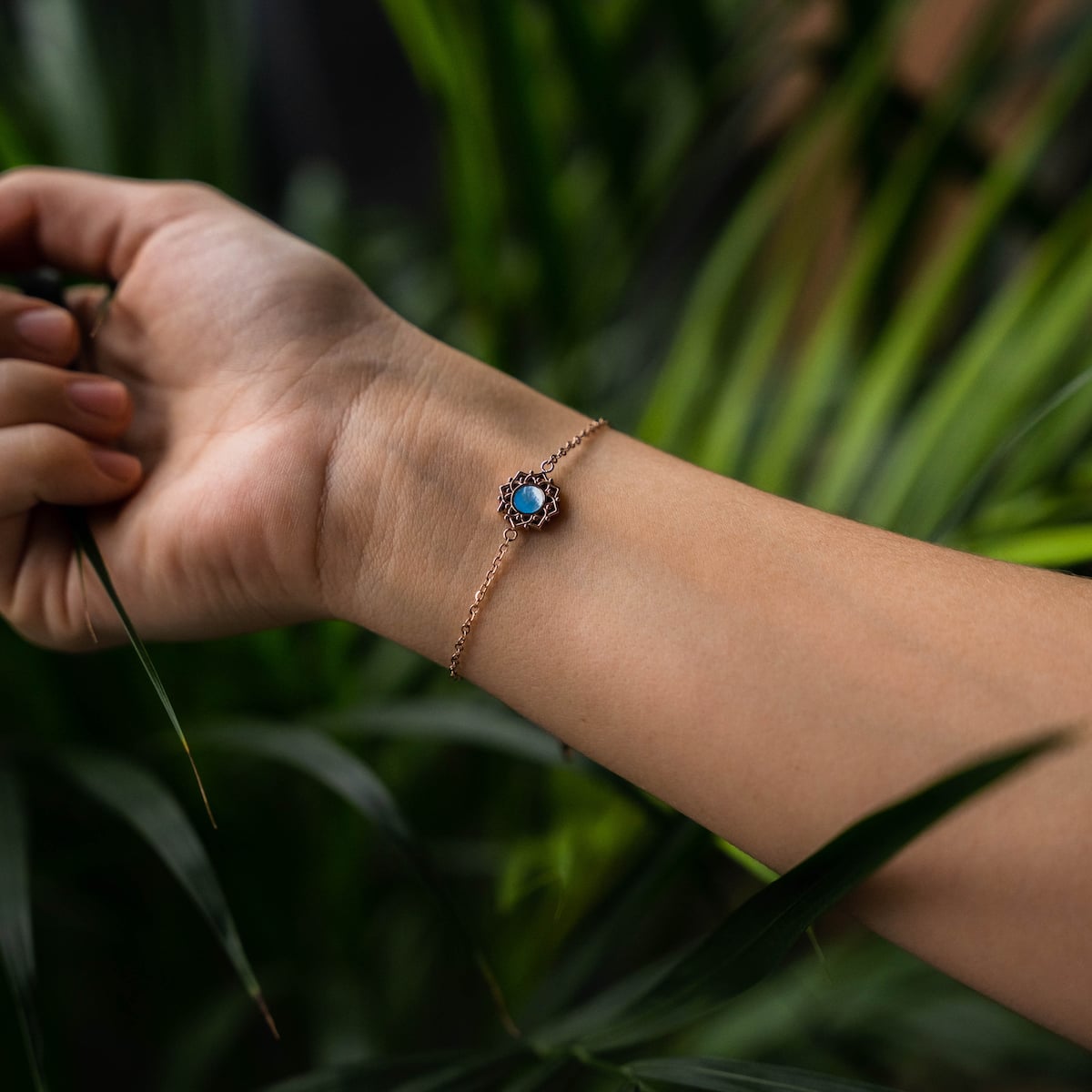 "Composition Bracelet": Elegant bracelet with blue nacre and rose gold accents, worn gracefully on wrist.