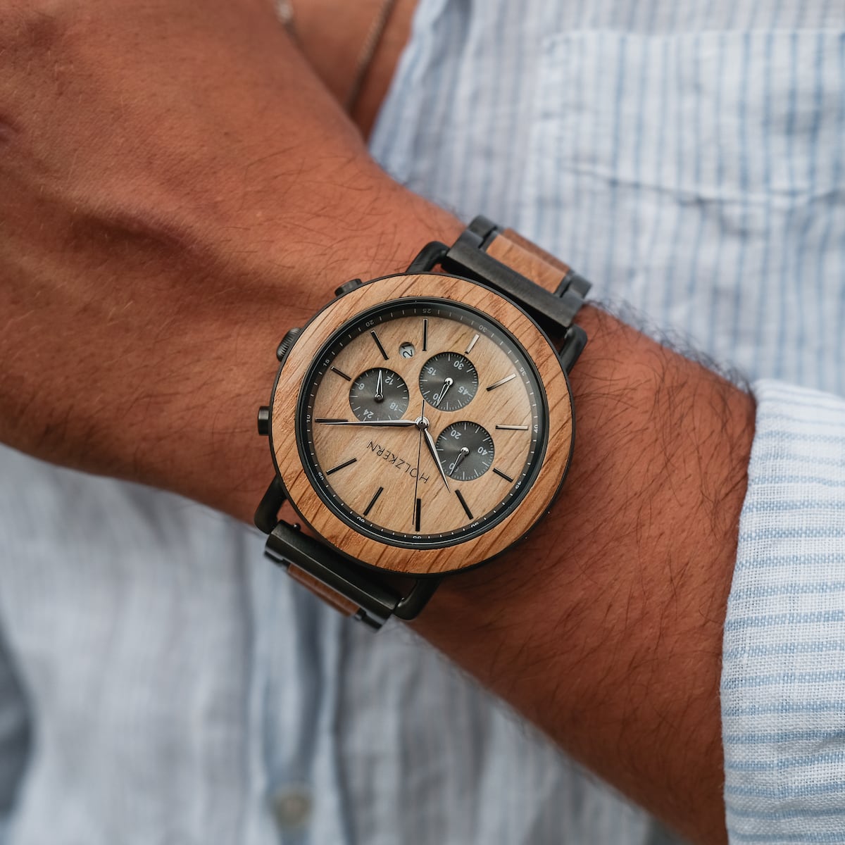 "Whakaari" elegant wristwatch with oak finish and chronograph design on a wrist.