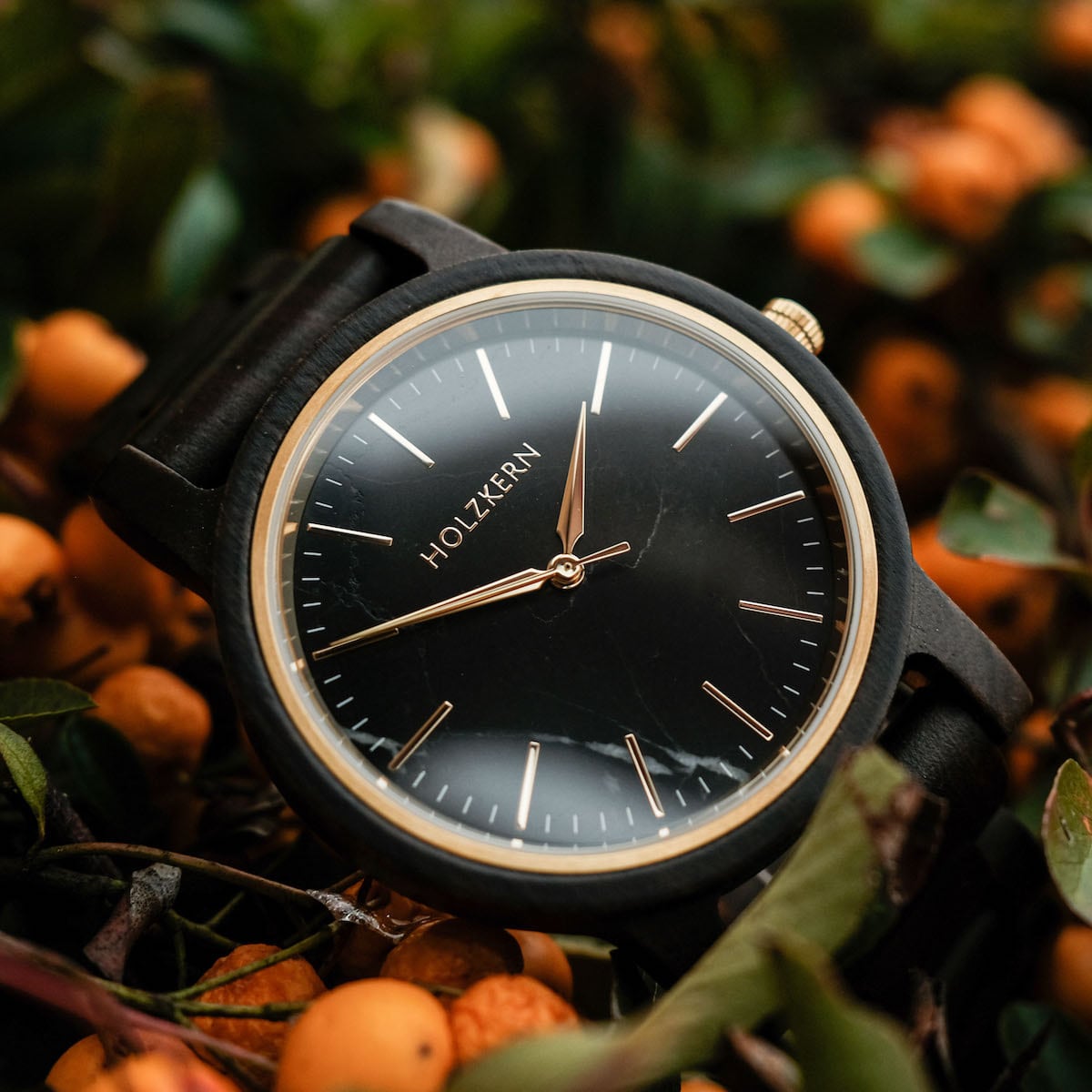 Orologio "Summer Night" con un elegante acero e un design in marmo, circondato da un vivace fogliame.