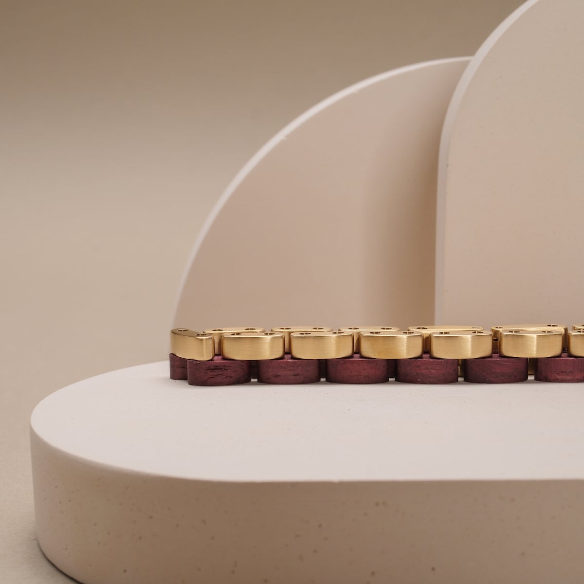 "Duet", a stylish bracelet in amaranth and gold with a modern, elegant design.