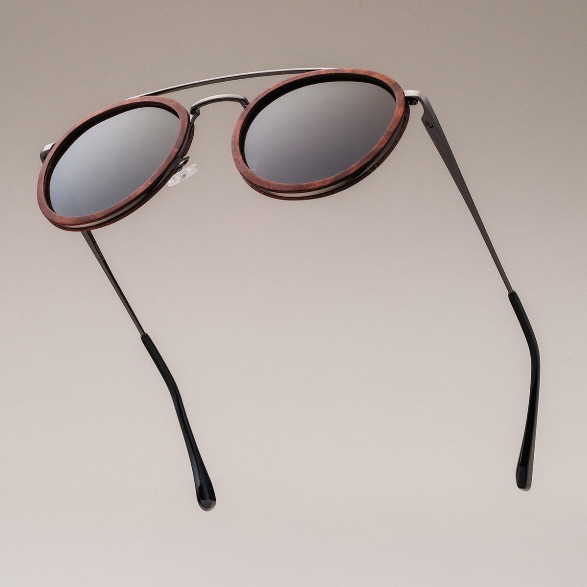 Occhiali da sole "Incanto" dal design vintage rotondo con finitura in noce e argento antico.