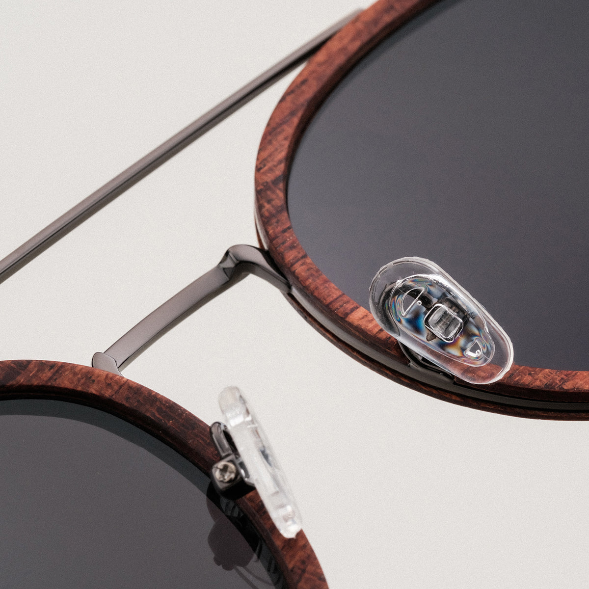Gli occhiali da sole "Incantesimo" sono caratterizzati da una cornice in noce e da antichi accenti in argento con un design elegante e moderno.