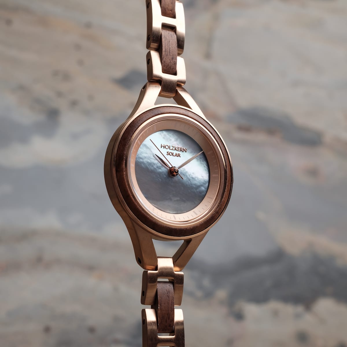 "Fatima", elegant watch in walnut and nacre, featuring a sleek solar design and luxurious craftsmanship.