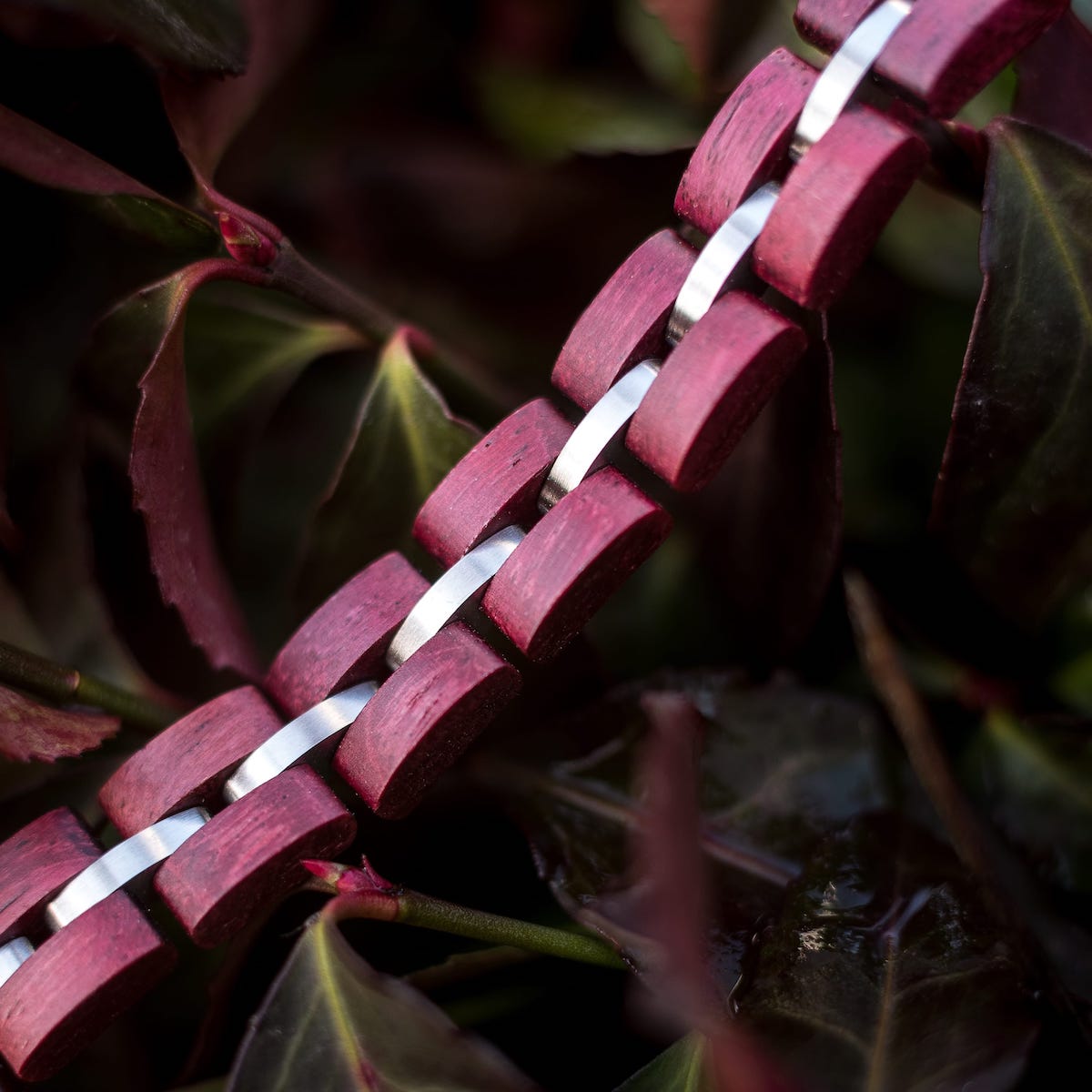 Bracciale "Fantasia" con accenti amaranto e argento, caratterizzato da un design naturale ed elegante.