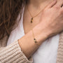 Bracciale "Mosaic" che mostra un design moderno in noce e oro mosaico su una catena delicata.