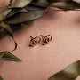 Orecchini a borchie "Effigy" in oro noce e rosa con un design minimalista.