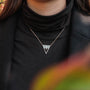 "Chiaroscuro Necklace necklace, triangle design featuring gray marble and rose gold, worn elegantly on a black turtleneck."