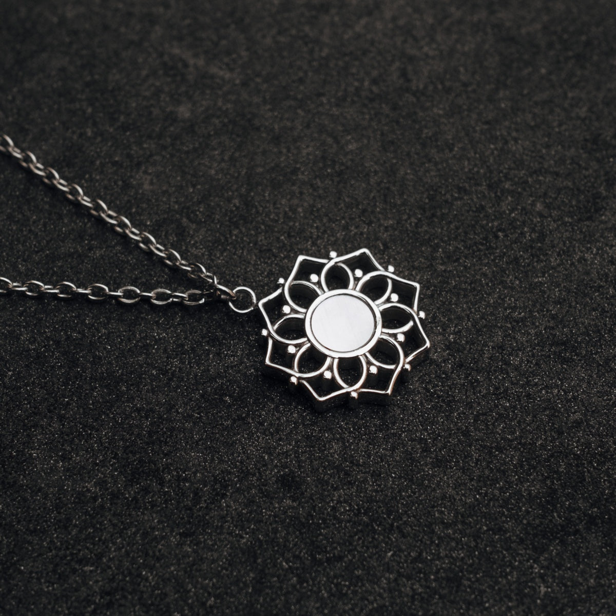 "Composition Necklace": silver necklace with white nacre, featuring an intricate design on a dark background.