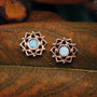 "Composition Earrings" earrings featuring intricate rose gold design and blue nacre accents, set against a natural backdrop.
