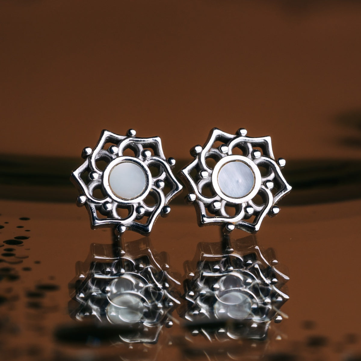 "Composition Earrings": Stylish silver earrings with intricate design and white nacre accents.