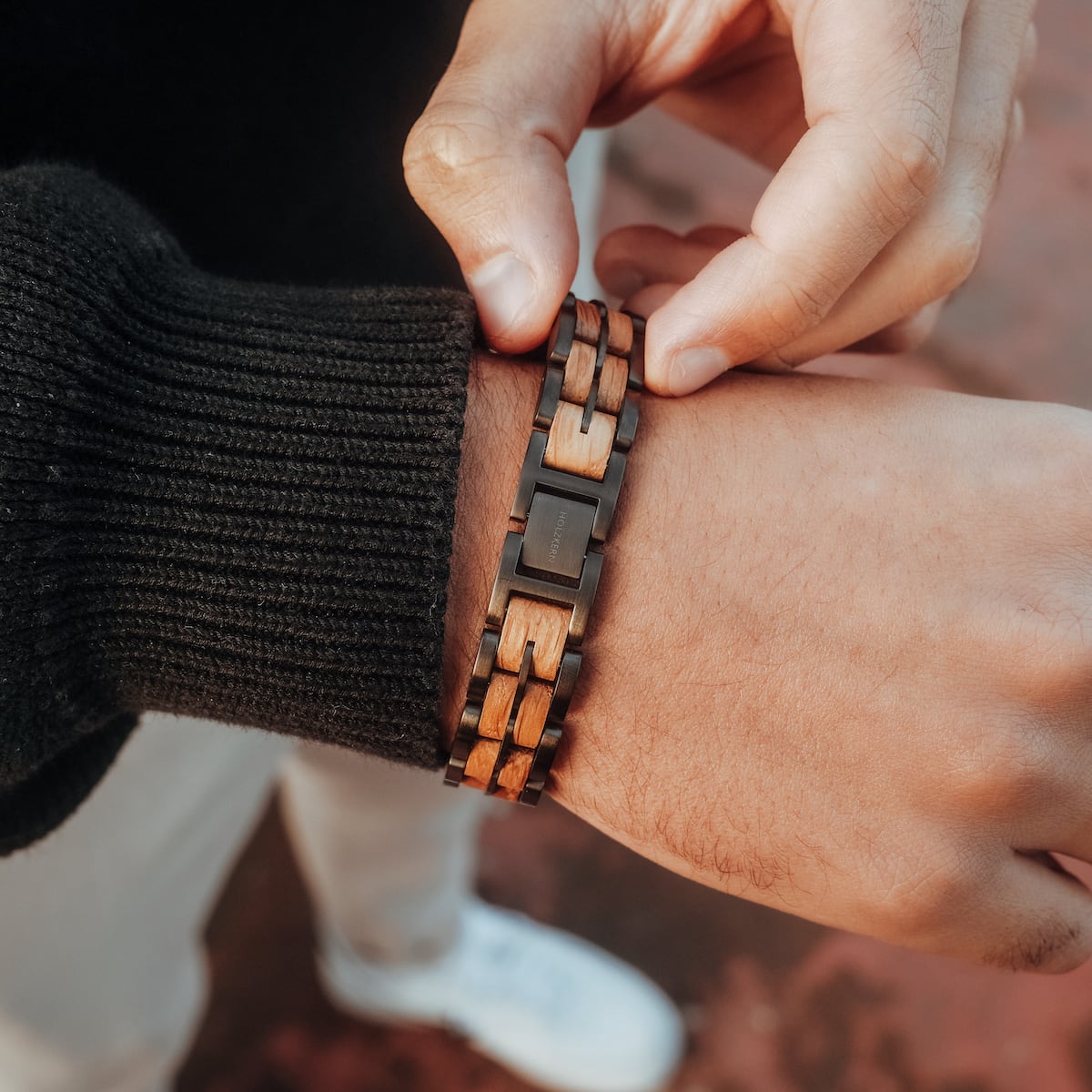 "Kanon", a stylish bracelet featuring oak and grey elements worn on wrist.