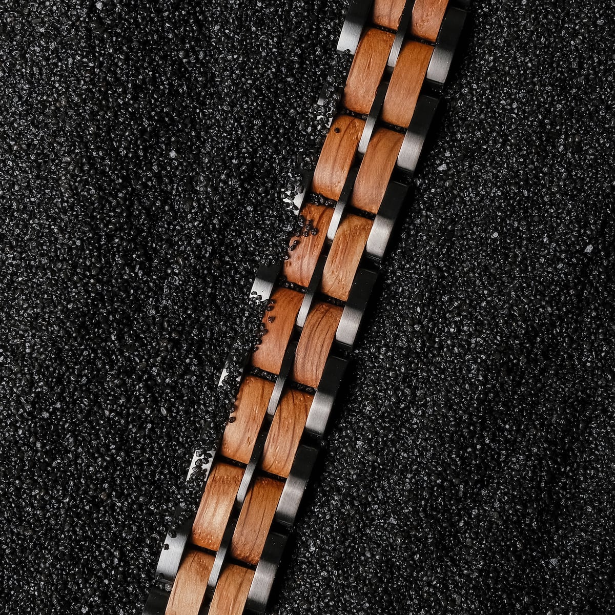 "Kanon", a stylish watch strap, features an oak and grey design set against a textured dark background.