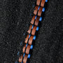 "Kanon" watch with walnut wood and blue accents on a textured black background.