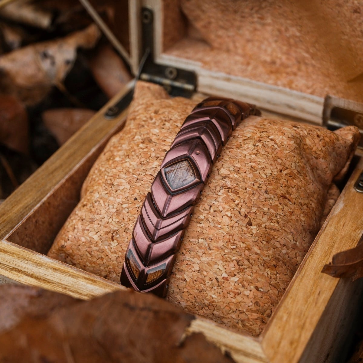 "Prelude" bracelet, crafted from walnut and copper, featuring a rustic, geometric design in a wooden box.