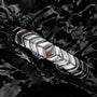 Bracciale "Prelude" con noce e argento, elegantemente modellato su uno sfondo nero riflettente.