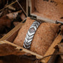 Bracciale "Prelude" in noce e argento, con un design geometrico elegante e esposto in una scatola in legno rustico.