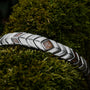 Bracciale "Prelude" in noce e argento, che mostra un design elegante e naturale su uno sfondo mossy.