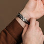Bracciale "Prelude" con un design elegante in noce e argento, indossato su un polso.