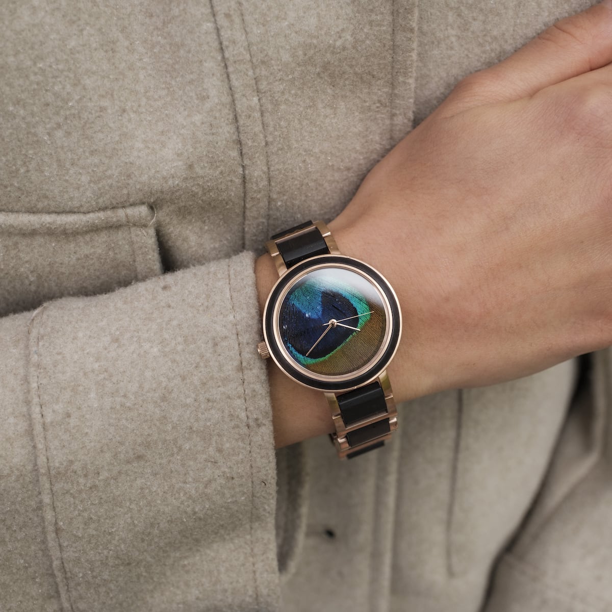 Orologio da polso "The Fearless" con un design in piuma d'acero e pavone, che mostra uno stile visivo elegante e vibrante.
