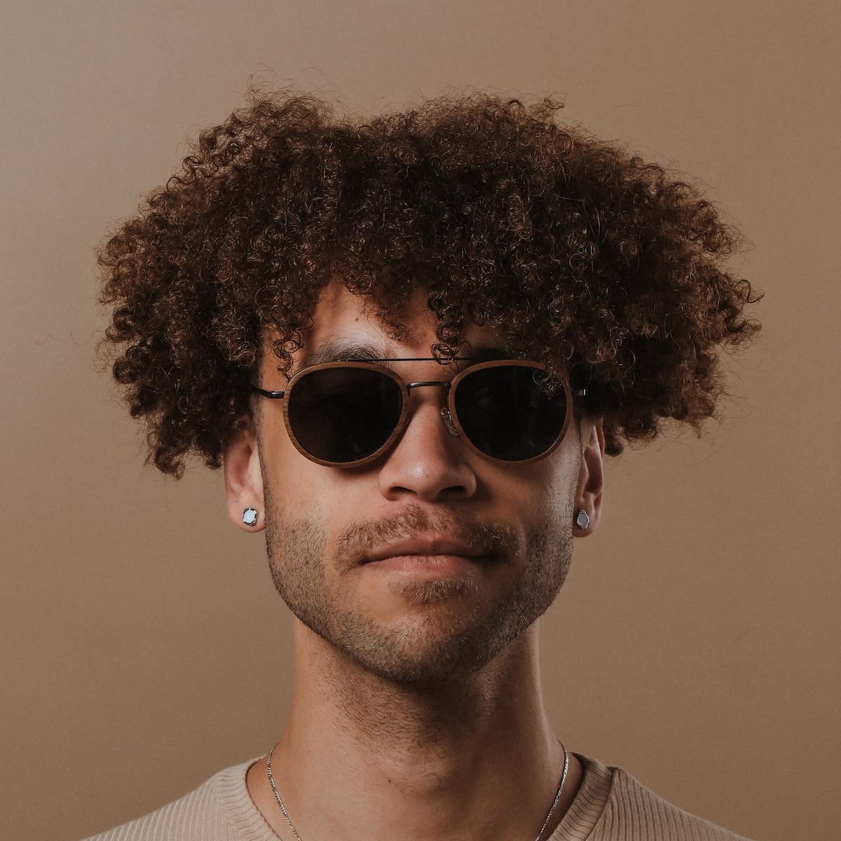 "The Risky" sunglasses in Walnut/Dark Grey, featuring a round frame and modern style.