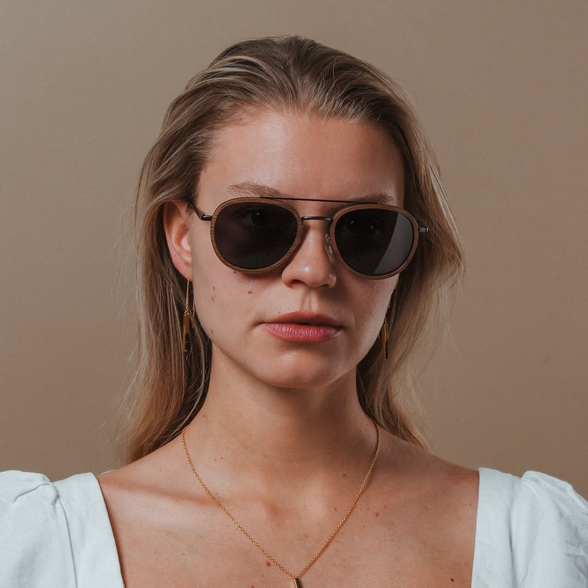 "The Risky" sunglasses, featuring a sleek walnut and dark grey style.