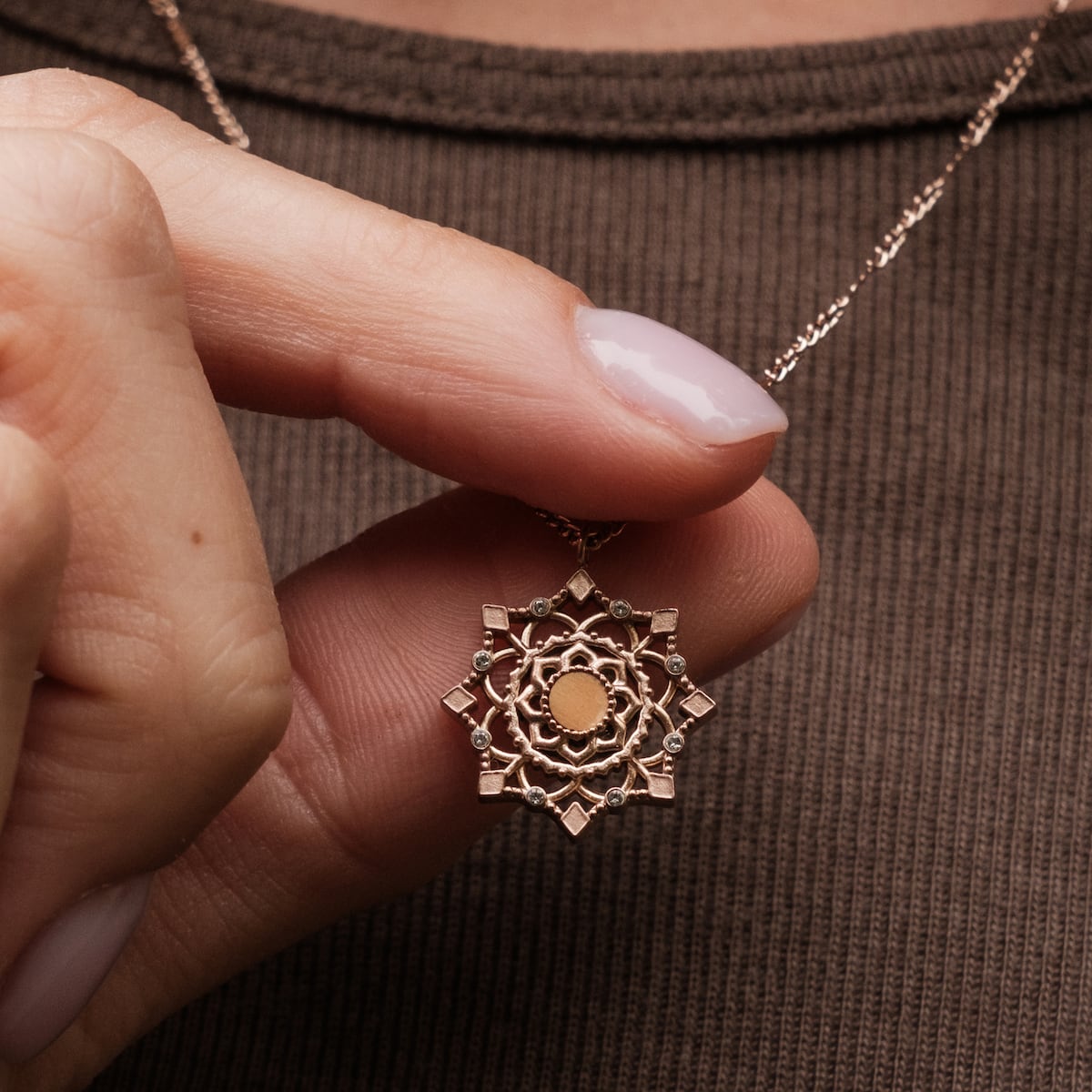 Collana "Aphonia" in oro e rosa con intricato design mandala.