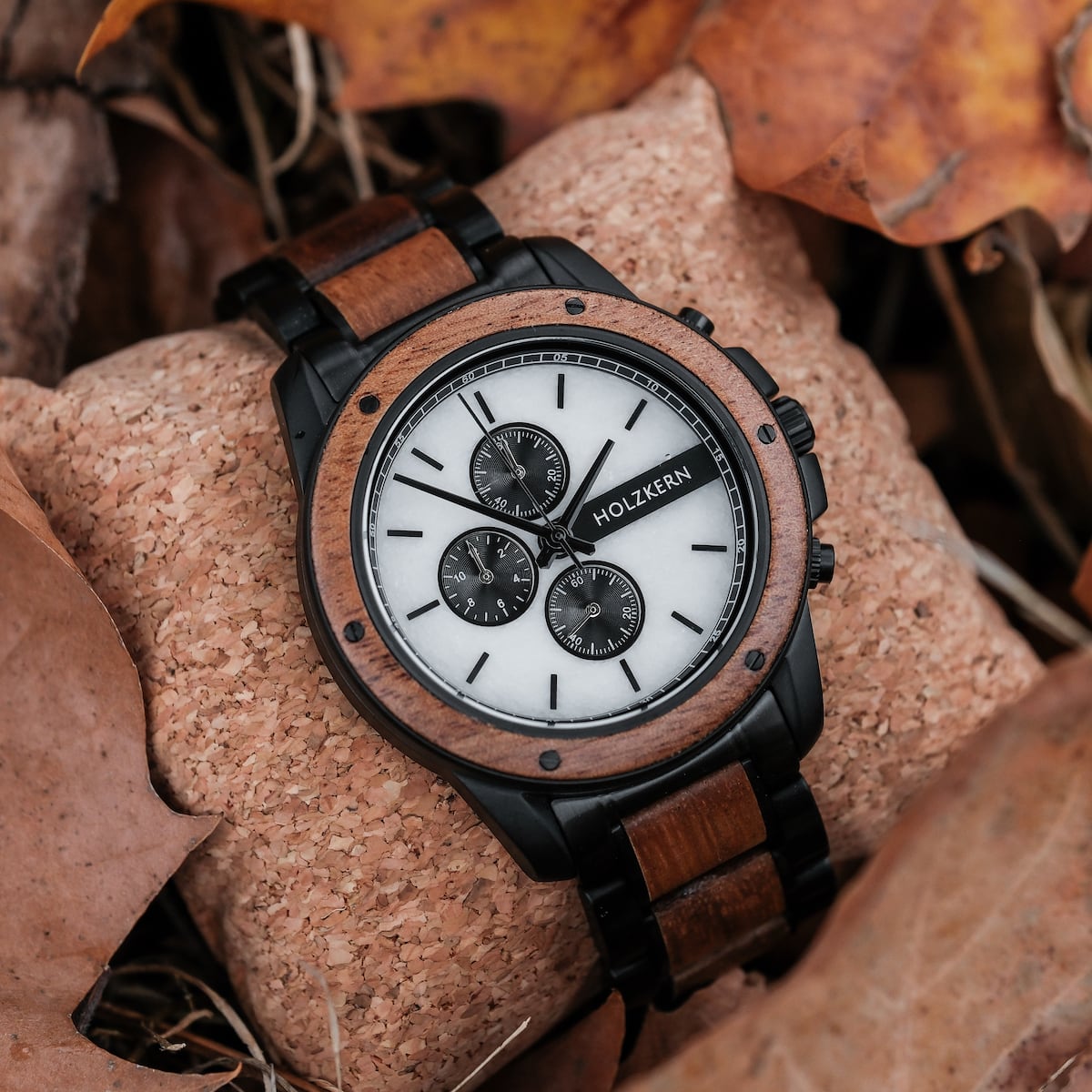 "Lancelot" watch featuring teak and marble design, surrounded by autumn leaves.