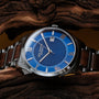 "Milestones watch with a sleek walnut and blue design, featuring Roman numerals and stainless steel accents."