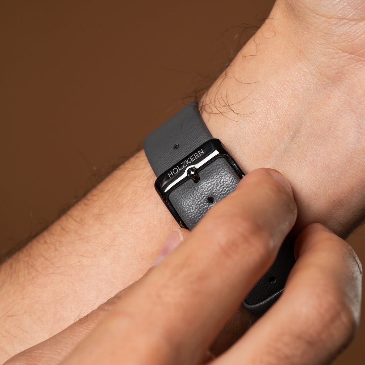 "Milestones" wristwatch featuring a dark gray strap and elegant styling.