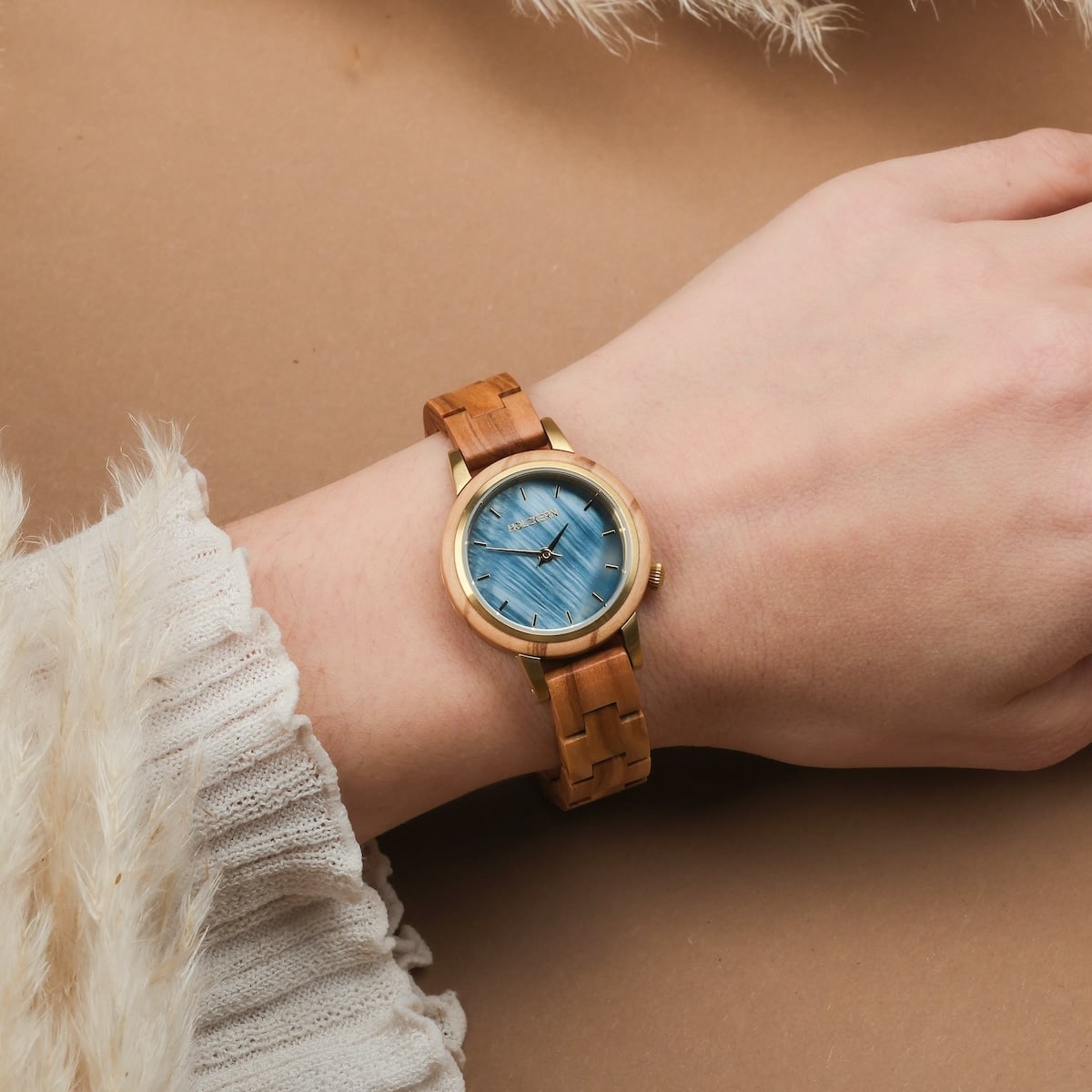 Orologio da polso "Antrim" con una fascia in legno e quadrante blu, elegantemente indossato su un polso.