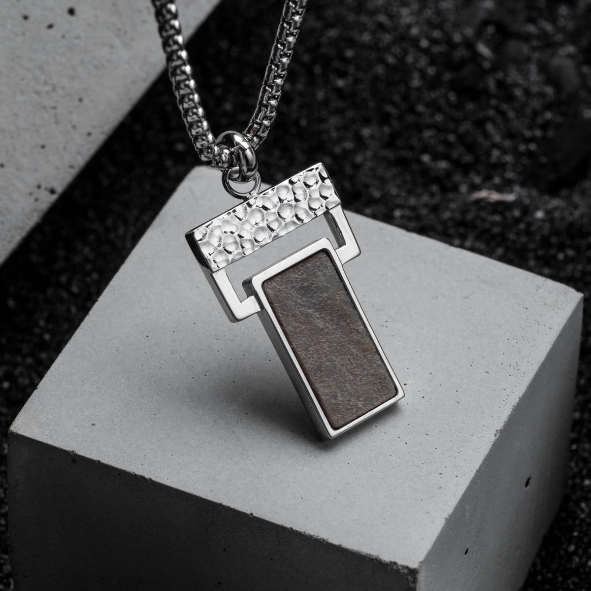 "Transcendent" pendant featuring a sleek slate and silver design with a modern, textured aesthetic.