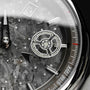 "DS9" watch with a marble and light gray dial, featuring sleek metallic accents and intricate detailing.