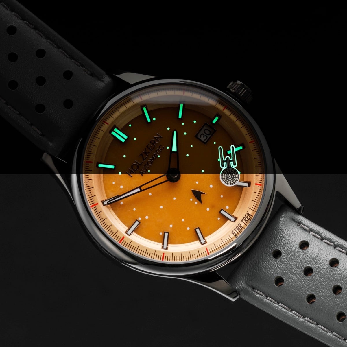 "NCC-1701", orologio da polso con un quadrante arancione vibrante e accenti giada, con un elegante cinturino grigio scuro.