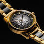Orologio da polso "Flowfinder", con un design in oro e acero con un quadrante elegante e una fascia metallica.