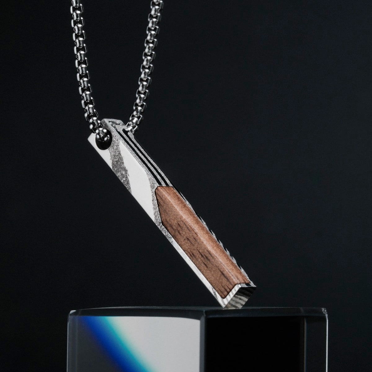 "Campania Necklace" necklace featuring a sleek walnut and Damascus design on a modern chain.