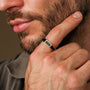 "Supremum Ring", a stylish marble and gold ring, showcases modern elegance on a man's finger.