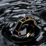 "Supremum Ring" ring, featuring a luxurious marble and gold design, elegantly showcased on a reflective surface.