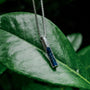 "Campania Necklace" necklace featuring a sleek design with Sodalite and Damascus materials against a natural backdrop.